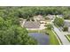 Aerial view of the house showing the roof, the property, surrounding trees, a pond, and other houses in the neighborhood at 5747 Fieldspring Ave, New Port Richey, FL 34655