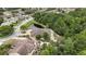 Aerial view of a suburban single-story home with mature trees and a pond in the backyard at 5747 Fieldspring Ave, New Port Richey, FL 34655