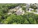 Aerial view of the house showing the roof, the property, surrounding trees, a pond, and other houses in the neighborhood at 5747 Fieldspring Ave, New Port Richey, FL 34655