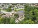 Aerial view of the house showing the roof, the property, surrounding trees, a pond, and other houses in the neighborhood at 5747 Fieldspring Ave, New Port Richey, FL 34655