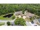 Expansive aerial view of brick home with a pond surrounded by lush greenery and other luxury homes nearby at 5747 Fieldspring Ave, New Port Richey, FL 34655