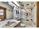 Bathroom featuring a sink, shower, toilet, and uniquely patterned tile at 5747 Fieldspring Ave, New Port Richey, FL 34655
