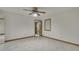 An empty bedroom with wood trim and a ceiling fan features a doorway to a bathroom at 5747 Fieldspring Ave, New Port Richey, FL 34655