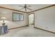 An empty bedroom with a ceiling fan, tiled floors, and a closet with mirrored doors at 5747 Fieldspring Ave, New Port Richey, FL 34655