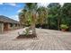 Spacious brick-paved driveway leading to a brick house with well-maintained landscaping and a charming outdoor statue at 5747 Fieldspring Ave, New Port Richey, FL 34655