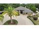 Aerial view of a single-story house with lush tropical landscaping and brick driveway at 5747 Fieldspring Ave, New Port Richey, FL 34655