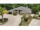 Expansive single-story home with lush tropical landscaping and a circular driveway at 5747 Fieldspring Ave, New Port Richey, FL 34655