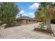 The brick home features lush landscaping, a charming statue, and a spacious brick-paved driveway, creating curb appeal at 5747 Fieldspring Ave, New Port Richey, FL 34655