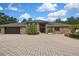 Elegant single-story home boasting a brick exterior and extensive circular paver driveway at 5747 Fieldspring Ave, New Port Richey, FL 34655