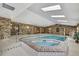 Bright indoor pool and jacuzzi room with brick walls and plenty of natural light at 5747 Fieldspring Ave, New Port Richey, FL 34655
