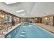 Large indoor pool with brick surround, tiled floor, skylights and a jacuzzi at 5747 Fieldspring Ave, New Port Richey, FL 34655