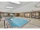 Bright indoor pool and jacuzzi room with brick walls and access to the outside at 5747 Fieldspring Ave, New Port Richey, FL 34655