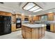 Spacious kitchen featuring a central island with granite countertop and ample storage at 5747 Fieldspring Ave, New Port Richey, FL 34655