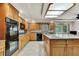 Well-equipped kitchen featuring oak cabinets, granite countertops, and modern appliances at 5747 Fieldspring Ave, New Port Richey, FL 34655