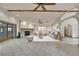 Comfortable living room featuring a stone fireplace, ceiling fan, tile flooring, and neutral-toned decor at 5747 Fieldspring Ave, New Port Richey, FL 34655