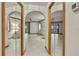 Spacious living room with tile floors, ceiling fan, two sets of sliding doors, and mirrored entryways at 5747 Fieldspring Ave, New Port Richey, FL 34655