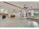 Open living room featuring tile floors, stone fireplace, ceiling fan, and an archway to another room at 5747 Fieldspring Ave, New Port Richey, FL 34655