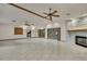 Large living room with tile flooring, stone fireplace, ceiling fan, and doors to the pool area at 5747 Fieldspring Ave, New Port Richey, FL 34655