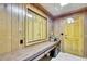 A wood paneled office features built in shelves and drawers, an exterior door, and white tile flooring at 5747 Fieldspring Ave, New Port Richey, FL 34655