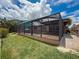 Backyard featuring a screened in patio, lush lawn, and a canal view at 6601 Nautical Isle, Hudson, FL 34667