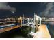 Night view of the private boat dock featuring a boat lift with wooden walkways and calm water reflecting the moonlight at 6601 Nautical Isle, Hudson, FL 34667