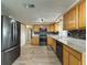 Well-lit kitchen with wood cabinets, granite counters, and stainless-steel refrigerator and appliances at 6601 Nautical Isle, Hudson, FL 34667