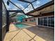 Inviting outdoor pool area with brick patio and screened enclosure at 6601 Nautical Isle, Hudson, FL 34667