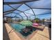 Lovely screened pool overlooking the water, complete with a playful flamingo and umbrella table feature at 6601 Nautical Isle, Hudson, FL 34667