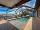 Inviting screened pool with a relaxing umbrella table and pink flamingo, offering a perfect backyard oasis at 6601 Nautical Isle, Hudson, FL 34667