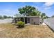 A view of the backyard with a screened-in patio, some greenery and a privacy fence at 6633 Jackson St, New Port Richey, FL 34653