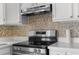 Stainless steel stove and backsplash complement the white cabinets and countertops at 6633 Jackson St, New Port Richey, FL 34653