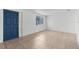 Bright and spacious living room featuring tile floors, a large window, and a vibrant blue front door at 6633 Jackson St, New Port Richey, FL 34653