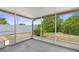 Enclosed porch overlooking a grassy backyard with garden growth along the white fence at 6633 Jackson St, New Port Richey, FL 34653