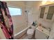 Bright bathroom with a shower-tub combo and a floral shower curtain at 7100 Ashwood Dr, Port Richey, FL 34668