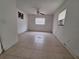 An empty bedroom with tile flooring, a ceiling fan, and a window AC unit at 7100 Ashwood Dr, Port Richey, FL 34668