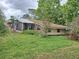 Angle view of stone cottage featuring a screened porch, unique architecture, and lots of natural light at 7100 Ashwood Dr, Port Richey, FL 34668