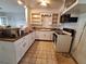 Kitchen view featuring white cabinets and an oven range with overhead microwave at 7100 Ashwood Dr, Port Richey, FL 34668