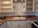 Functional kitchen featuring white cabinets, ample counter space and a vintage sink with chrome fixtures at 7100 Ashwood Dr, Port Richey, FL 34668