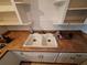 The kitchen sink is a double bowl sink with white cabinets and a brown countertop at 7100 Ashwood Dr, Port Richey, FL 34668