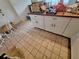 Kitchen featuring white cabinets, brown countertops, and tile flooring at 7100 Ashwood Dr, Port Richey, FL 34668