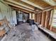 Unfinished room with exposed framing, window, door, and a water heater at 7100 Ashwood Dr, Port Richey, FL 34668