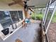Cozy screened porch featuring tile flooring, ceiling fan, and stone accents for comfortable outdoor living at 7100 Ashwood Dr, Port Richey, FL 34668