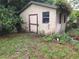 Exterior view of shed with a wooden door, small window, and plant life on top at 7100 Ashwood Dr, Port Richey, FL 34668