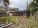 Backyard view with screened pool enclosure and mature trees enhancing privacy at 7119 Lenape Cir, New Port Richey, FL 34653