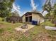 Home exterior with fire pit, recycling bins, and enclosed pool in the backyard at 7119 Lenape Cir, New Port Richey, FL 34653