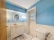 Charming bathroom with light blue walls, white wainscoting, and a vanity with storage at 7119 Lenape Cir, New Port Richey, FL 34653