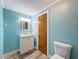 Stylish bathroom with blue walls, a white vanity, and modern fixtures at 7119 Lenape Cir, New Port Richey, FL 34653