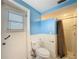 Fresh bathroom with blue walls, white wainscoting, and a convenient shower with curtain at 7119 Lenape Cir, New Port Richey, FL 34653