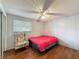 Cozy bedroom featuring wood-look floors, a ceiling fan, and a comfortable floral chair at 7119 Lenape Cir, New Port Richey, FL 34653