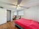 Well-lit bedroom with wood-look floors, a ceiling fan, and a mirrored closet at 7119 Lenape Cir, New Port Richey, FL 34653